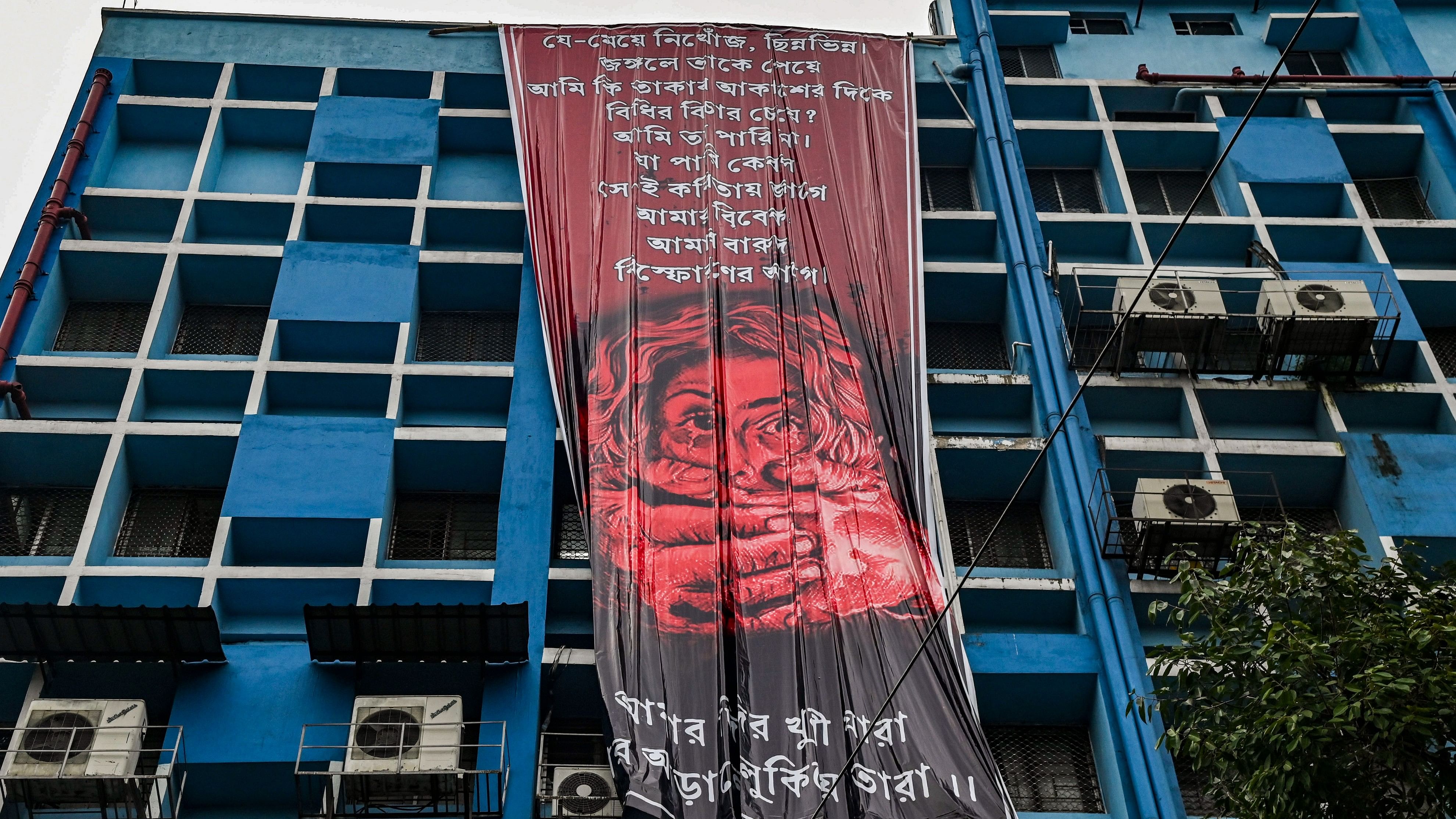 <div class="paragraphs"><p>Junior doctors hang a giant poster from the roof of the R G Kar College and Hospital during their protest against alleged rape and murder of a woman trainee doctor of the hospital, in Kolkata.</p></div>